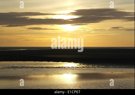 Ciel jaune soleil au-dessous des nuages gris de Plage avec sable humide sunglow ondulations, St Annes, Fylde Coast, UK Banque D'Images