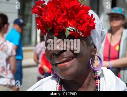 Portrait de voyage, bonne femme cubaine locale pose avec chapeau de fleur rouge, souriant, la Habana Vieja, la Vieille Havane, Cuba Banque D'Images