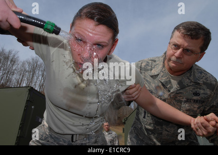 Les cadres supérieurs de l'US Air Force Airman Terina Miller, un membre des forces de sécurité avec la 130e Airlift Wing, récupère une fois pulvérisé Banque D'Images