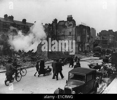 World War 2, Bataille d'Angleterre. Les Londoniens à pied à travers une rue avec leurs bicyclettes et d'un landau pendant la Banque D'Images