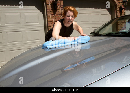 Appliquer de la cire femme à sa voiture de sport Banque D'Images