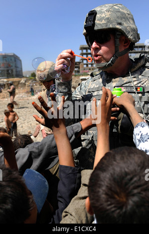 Le capitaine de l'ARMÉE AMÉRICAINE Michael Wikstrom, un aumônier avec Combined Security Transition Command - Afghanistan, montre comment les enfants afghans Banque D'Images