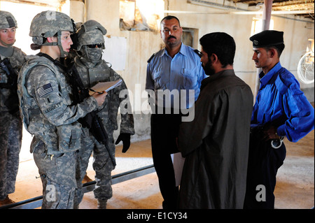 La 1ère Armée américaine, le Lieutenant Julie Leggett, gauche, et des policiers irakiens de parler avec le propriétaire d'une ferme d'élevage de poulets près de Tikrit, en Irak, en août. Banque D'Images