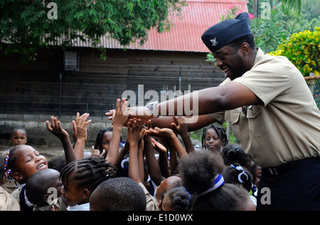 La marine militaire américaine du navire 2e classe Bryan Johnson, déployés à bord de navires à grande vitesse Swift (HSV 2), joue avec les enfants durin Banque D'Images