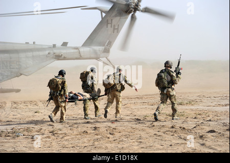 U.S. Air Force pararescuemen transporter une victime simulée d'un Marine Corps MH-53 Super Stallion lors d'hélicoptère Banque D'Images