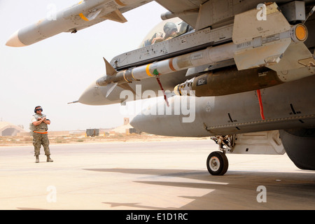 U.S. Air Force Tech. Le Sgt. Nathan Barnes se prépare pour signaler le Capitaine Jeremy Sorenson à taxi son F-16 Fighting Falcon block 30 airc Banque D'Images