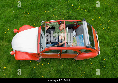 Vue de dessus de deux personnes, un couple dans une voiture avec le toit ouvert. Banque D'Images