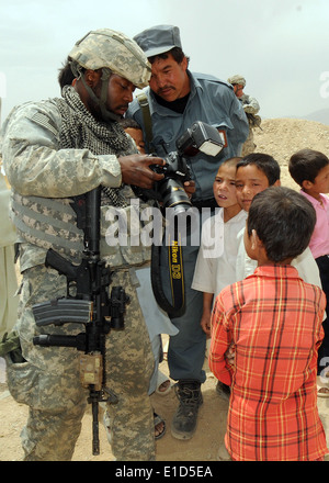 U.S. Air Force Tech. Le Sgt. Mai JT III, un photographe avec l'Équipe de reconstruction provinciale de Ghazni, nationale afghane montre poli Banque D'Images