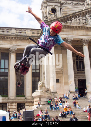 Un jeune de dix ans vieux scooter rider effectue une cascade aérienne en face de la Portsmouth Guildhall au cours de la rue de Portsmouth en 2014 Banque D'Images