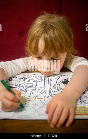 4 quatre ans, fille, et le dessin et le coloriage de avec des crayons Banque D'Images