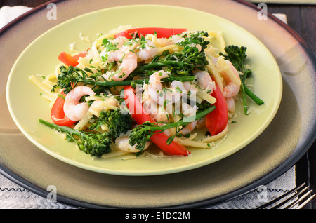 Linguine aux crevettes, broccolini et poivrons rouges sur une surface en bois Banque D'Images