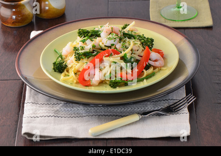 Linguine aux crevettes, broccolini et poivrons rouges sur une surface en bois Banque D'Images