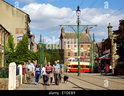 Les touristes, les lignes de tramway et une vieille dans la rue principale de la ville édouardienne qui fait partie de Beamish Museum en Angleterre. Banque D'Images