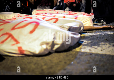 Sao Paulo, Brésil. 31 mai, 2014. Huit manifestants s'étendit sur la rue, couvrir avec les feuilles de 'corps', de se rappeler les travailleurs qui sont morts en service à la construction de stades pour la Coupe du Monde au Brésil (en fait il y a eu 9 morts), au cours de la 9e manifestation contre la Coupe du Monde à São Paulo, Brasil, ce samedi 31 mai, 2014. Environ 600 personnes ont marché à travers le centre-ville de São Paulo criant des slogans contre la Fifa, la police, et la mauvaise qualité des services publics, en dépit de la R 28 milliards de dollars (environ 12 milliards de dollars) dans les infrastructures de la compétition - aéroports, stades, l'expropriation des maisons, etc Banque D'Images