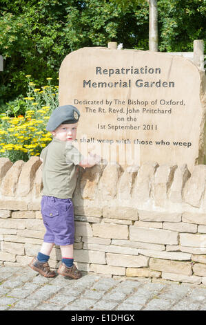 Carterton, UK. 1er juin 2014. Un jeune enfant portant sa mère RAF cap à l pierre commémorative à Norton, Carterton. Jusqu'à 10 000 motos sont de prendre part à une promenade dans l'Oxfordshire de Dry Sandford à Carterton pour rendre hommage aux braves hommes et femmes tués en service et remercier les communes pour leurs soins de nos héros et leurs familles. Credit : Desmond Brambley/Alamy Live News Banque D'Images