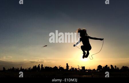 Berlin, Allemagne. 31 mai, 2014. La silhouette d'une jeune fille sautant à la corde sur Tempelhofer Feld à Berlin, Allemagne, 31 mai 2014. Photo : Spata Ole/dpa/Alamy Live News Banque D'Images