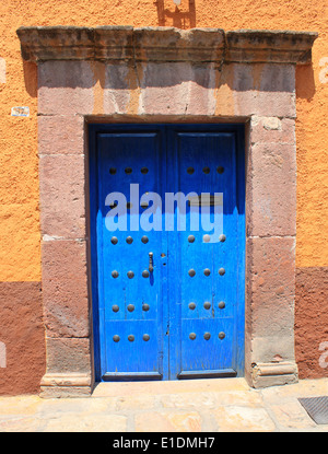 Porte bleu vif et porte en pierre contre le mur jaune dans le bâtiment colonial de San Miguel de Allende, Guanajuato, Mexique Banque D'Images