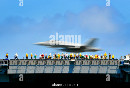 Les marins américains observer une AF/18F Super Hornet affectés à l ?Sunliners ? Grève de l'Escadron de chasse 81 comme il fait une une Banque D'Images