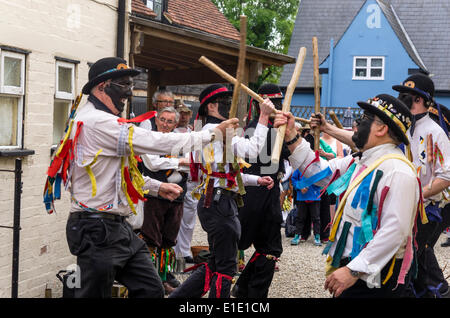 Morris men silurien de Ledbury dans le Herefordshire dancing at the Bell Inn en grand Bardfield Essex Royaume Uni le 31 mai 2014. Ce style de danse avec un visage noir est traditionnel dans la frontière galloise. La ferme a-t-il les mains pour empêcher l'agriculteur trouver qui ils étaient. Les danseurs participent à un festival appelé la morris ring qui a lieu chaque année dans la région de Thaxted depuis 1934 Banque D'Images