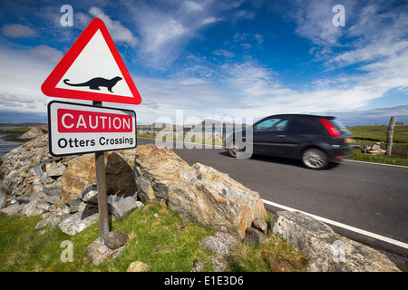 Les loutres attention crossing road sign avec passé de conduite du véhicule. Hébrides extérieures, en Écosse, Royaume-Uni Banque D'Images