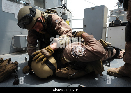 U.S. Coast Guard maître de Manœuvre 1re classe Jon Tatroe tend à la simulation d'un membre de l'équipe au sol à partir de la Garde côtière des États-Unis L Tactique Banque D'Images