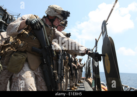 Le Corps des Marines des États-Unis. David Beltz regarde au-dessus de sa cible lors d'un programme de tir de combat à bord du USS Kearsar exercice Banque D'Images