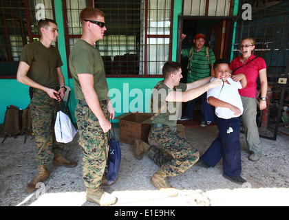 Le sergent du Corps des Marines des États-Unis. Kyle W. Cucci aide un enfant du Costa Rica mis sur un sac à dos rempli de fournitures scolaires à l'Hone Creek Scho Banque D'Images