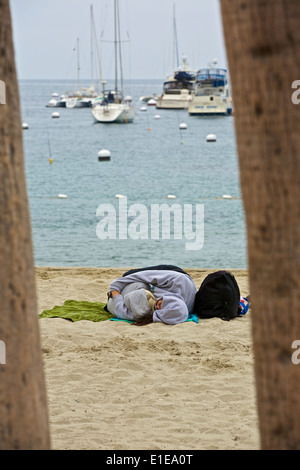 Matin Après la nuit d'avant. Deux femmes de dormir sur la plage à Avalon, Catalina Island, Californie. Banque D'Images