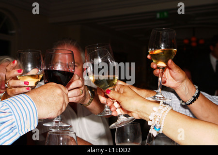 Gens qui élèvent verres de vin dans un toast lors d'un dîner d'anniversaire célébration Banque D'Images