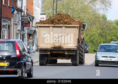 Un tracteur tirant un récipient de fumier sur les high street de Tenterden dans le Kent, Angleterre Banque D'Images