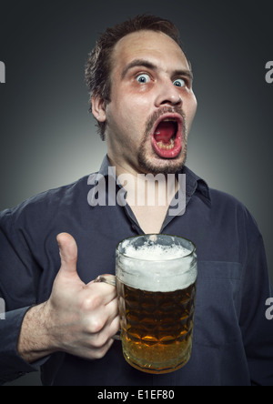 L'homme satisfait avec de la bière sur un fond sombre. Studio de photographie. Banque D'Images