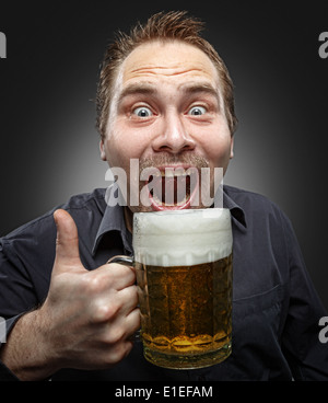 L'homme satisfait avec de la bière sur un fond sombre. Studio de photographie. Banque D'Images