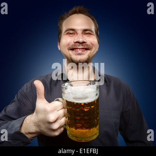 L'homme satisfait avec de la bière sur un fond sombre. Studio de photographie. Banque D'Images