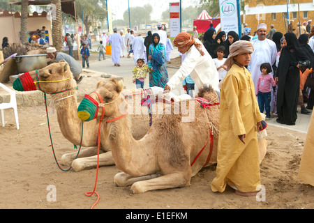 Omanis en costume traditionnel, avec une paire de chameaux, dans une rue de Mascate, dans le Sultanat d'Oman. Banque D'Images