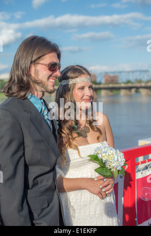 Mariée et le marié avec une rivière et le pont en arrière-plan Banque D'Images