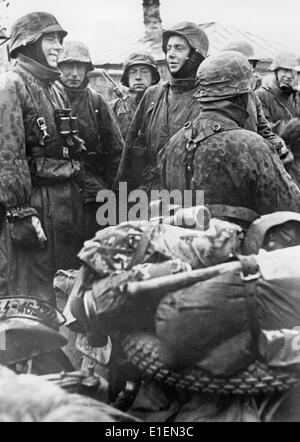 Texte de propagande! De l'information nazie sur le dos de la photo: "Le convoi s'arrête! Un pilote de moto Dispatch, doué d'humour et d'humour, divertit ses camarades et les fait oublier le froid. » (Défauts de qualité dus à la copie historique de l'image) Fotoarchiv für Zeitgeschichtee - PAS DE SERVICE DE FIL - Banque D'Images