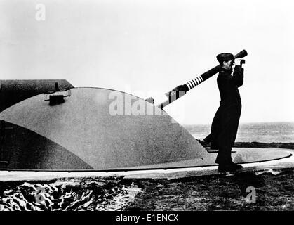 La photo d'un reportage nazi montre un soldat de l'armée allemande regardant à travers des jumelles une fortification le long du mur de l'Atlantique en avril 1943. Le texte original au dos de la photo indique : « les anneaux sur le canon montrent que l'ennemi a tenté d'attaquer les vastes fortifications à plusieurs reprises. » Fotoarchiv für Zeitgeschichtee - PAS DE SERVICE DE FIL Banque D'Images