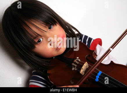 Enfant mignon regardant la caméra avec un violon dans les mains Banque D'Images