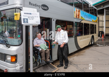 Homme handicapé en fauteuil roulant à la sortie de bus. Reading, Berkshire, England, GB, au Royaume-Uni. Banque D'Images