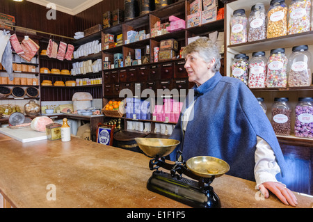 Une femme sert dans un ancien magasin général Banque D'Images