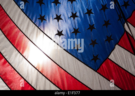 US stars and stripes flag flying contre le soleil dans un fond de ciel bleu, New York. Banque D'Images