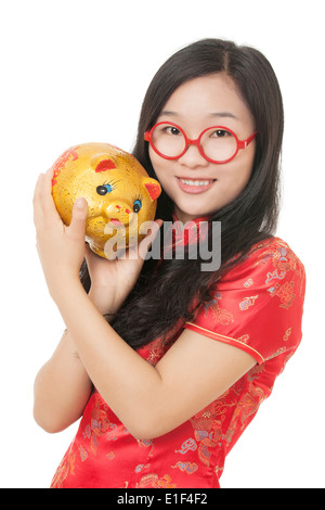 Belle femme chinoise portant une robe traditionnelle connue sous le nom d'un Chipao holding a piggy bank Banque D'Images