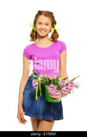 Cheerful girl holding pail avec des tulipes roses Banque D'Images