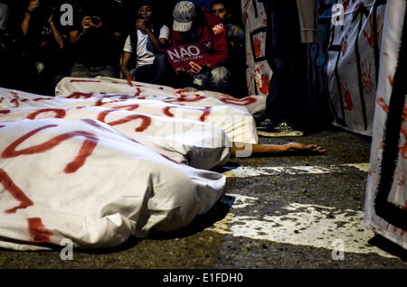 31 mai 2014 - SÃ£o Paulo, Brésil - SÃƒO Paulo, Brasil-Mai 31 : Huit manifestants s'étendit sur la rue, couvrir avec les feuilles de 'corps', de se rappeler les travailleurs qui sont morts en service à la construction de stades pour la Coupe du Monde au Brésil (en fait il y a eu 9 morts), au cours de la 9e manifestation contre la Coupe du Monde de SÃ£o Paulo, Brasil, ce samedi 31 mai, 2014. Environ 600 personnes ont marché à travers le centre-ville de SÃ£o Paulo criant des slogans contre la Fifa, la police, et la mauvaise qualité des services publics, en dépit de la R 28 milliards de dollars (environ 12 milliards de dollars) dans les infrastructures de la compétition - aéroports, stades Banque D'Images