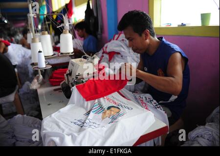 Jakarta, Indonésie. 3 juin, 2014. Un travailleur coud un T-shirt avec photo du candidat présidentiel indonésien Joko Widodo à Jakarta, Indonésie, le 3 juin 2014. L'Indonésie est d'organiser les élections présidentielles le 9 juillet. © Zulkarnain/Xinhua/Alamy Live News Banque D'Images