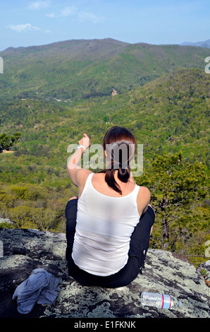 Une femme assise sur un randonneur donnent sur la montagne en montrant un point de repère. Banque D'Images