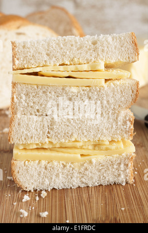 Style rustique part couper le fromage Cheddar sandwich fait avec du pain fait maison Banque D'Images