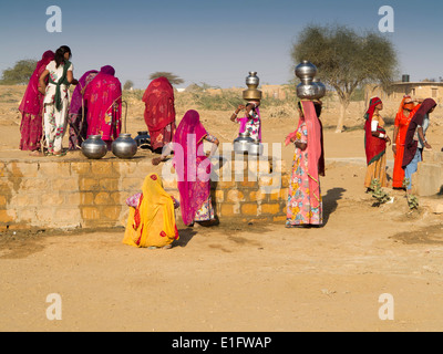 L'Inde, Rajasthan, Jaisalmer, désert du Thar, Khuri, les femmes vêtues de saris colorés à la collecte de l'eau du puits du village Banque D'Images