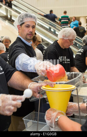 Auburn Hills, Michigan, USA. Chrysler employés bénévoles préparent des forfaits repas pour cesser la faim maintenant, un organisme de secours de la faim. Les aliments doivent être envoyées au Brésil à l'appui de programmes d'alimentation scolaire. Crédit : Jim West/Alamy Live News Banque D'Images