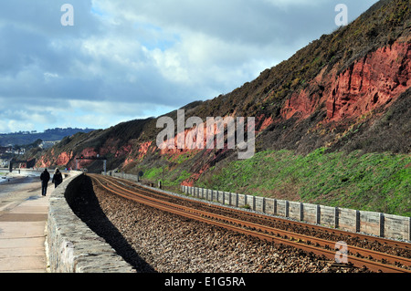 Une falaise de grès rouge de la section ancienne, près de Exmouth, dans le sud du Devon - stratigraphie du Dévonien et montrant la ligne de chemin de fer. Banque D'Images